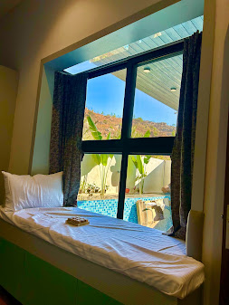 Bedroom with poolside view and blue curtains